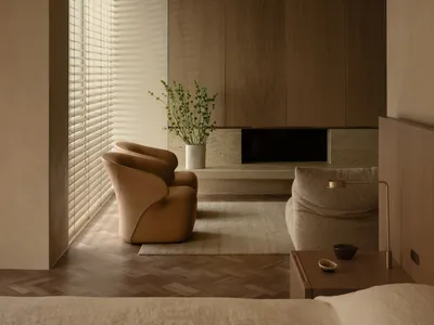 Cozy living room with a brown color scheme, a couch, a chair, and a fireplace, well-lit and inviting