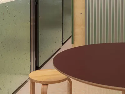 昏暗空間中擺放著棕色餐桌和椅子的餐廳區，周圍散落著各式家具，營造出溫暖的氛圍