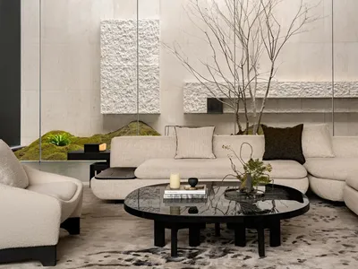 A modern living room with a black coffee table, couch, and chair, decorated with potted plants and featuring clean lines and minimalistic decor