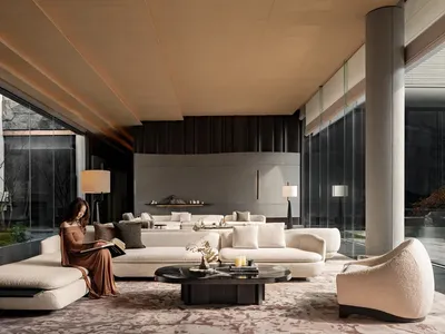 A well-lit living room with a woman reading on a couch, surrounded by white furniture, vases, and a dining table