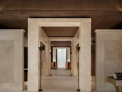 Luxurious living room with marble flooring and walls, soft warm lighting, and comfortable furniture