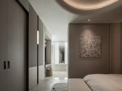 A calm and inviting bedroom with a grey bed, white walls, a mirror, and a painting on the wall