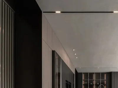 A dimly lit modern kitchen with wooden countertops, a sink, oven, and refrigerator