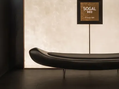 A dimly lit hotel hallway with a white wall and a brown wooden door, featuring a sign on the wall