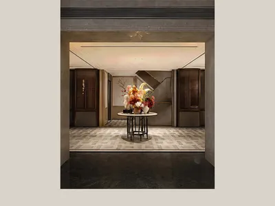 Fancy hotel entrance with a large vase, marble or granite surfaces, and neutral colors creating a welcoming atmosphere