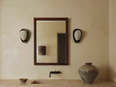 Cozy bathroom with a brown color scheme, featuring a sink, mirror, and vase, under dim lighting