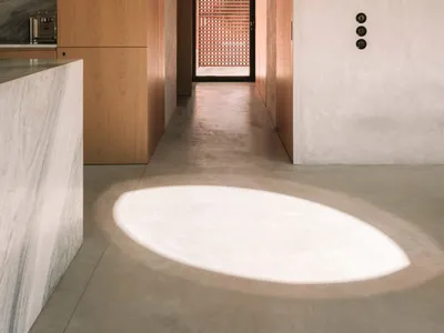 現代廚房與走廊區域，白色的表面、廚房檯面、餐桌，以及從窗戶灑入的自然光