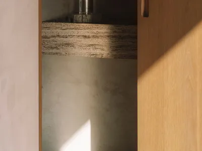 Bathroom with a sink and a bottle on the counter, surrounded by wooden surfaces and dim lighting
