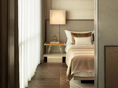 Cozy bedroom with a wooden floor, white curtain, and natural light from an open window