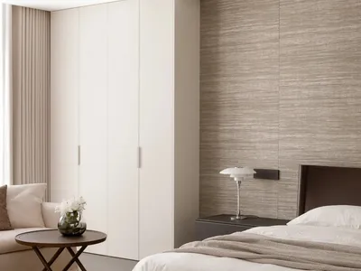 Cozy bedroom with a bed, couch, and table in a white color scheme, with natural light from a window