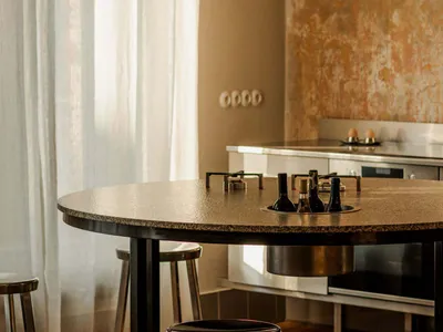 A residential kitchen with a dining table and chairs, black and white color scheme, and natural light creating a bright and clean atmosphere