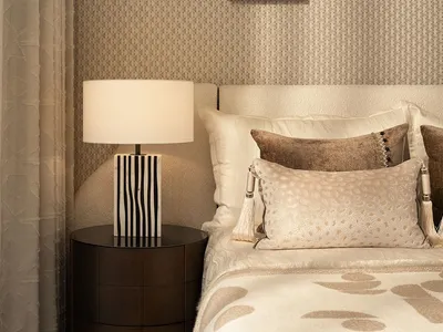 Cozy bedroom with a white comforter, a bedside lamp, and a framed artwork on the wall