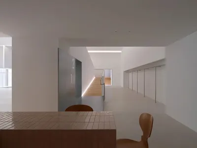 溫馨餐廳空間，棕色餐桌搭配大理石桌面，周圍為白色牆面與少量棕色元素，營造昏黃舒適氛圍