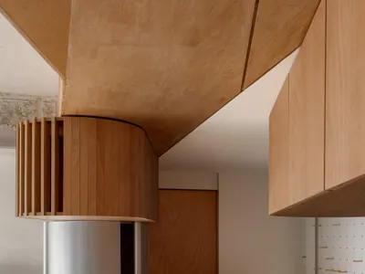 Well-lit kitchen with wooden cabinets, concrete countertops, and a modern design