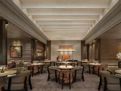A modern restaurant with a large dining area featuring wooden tables, metal accents, and dim lighting, creating a cozy and intimate atmosphere