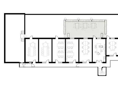 Black and white architectural floor plan of a long narrow restaurant featuring multiple dining rooms, a large outdoor terrace with trees, kitchen, and restrooms.