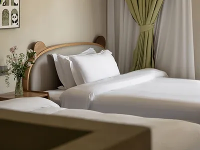 現代兒童臥室，展示兩張鋪有白色寢具的單人床、木製床頭板、帶厚實繩網的安全 loft 上下舖、鼠尾草綠窗簾，以及熊貓主題牆面藝術。