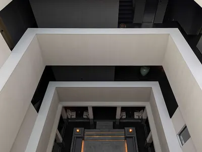 現代建築中庭俯視圖，包含下沉式石材庭院、嵌入式照明，以及周圍白色與深灰色牆面。