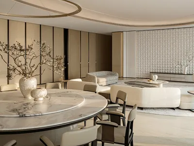 Modern luxury open-plan living and dining area featuring a large round white marble dining table, sculptural circular pendant light, curved ceiling, and neutral-toned contemporary furniture.