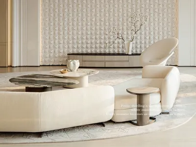 Modern minimalist living room featuring a curved off-white boucle sofa, sculptural lounge chair, marble coffee tables, and a large textured geometric feature wall in neutral tones.