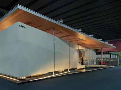 現代混凝土展館，採用大面積混凝土板、木質天花板懸挑，以及夜晚底部發光的線性LED燈。