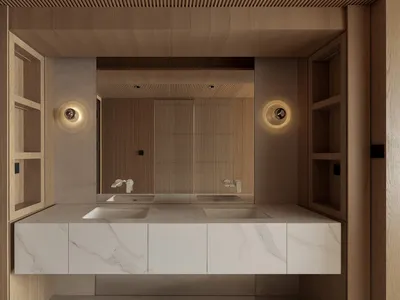Modern minimalist bathroom with double white marble sinks set in a floating vanity, flanked by tall light oak shelving units and circular wall sconces, with a large mirror reflecting a wood slat accent wall.
