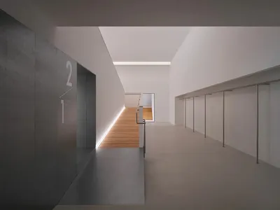 現代極簡風室內走廊，灰色混凝土牆面、淺色橡木地板、隱藏式LED燈帶，遠處可見懸浮樓梯。