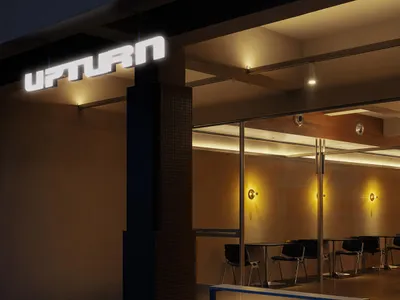 Night view of a modern cafe entrance featuring a large illuminated 'UPTURN' sign, a dark mosaic-tiled structural pillar, and a minimalist blue bench in the foreground.