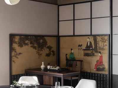 現代餐廳空間，設有大型圓形黑大理石餐桌與轉盤、白色的軟墊座椅，以及醒目的多聯中式屏風，上面繪有古典文人水墨畫。