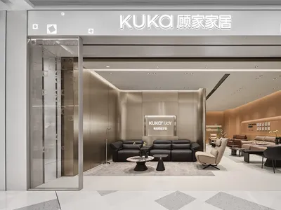 現代家具展廳內部，陳列黑色與米色皮革沙發、圓形大理石茶几，以及在明亮嵌燈照明下的淺木質板牆。