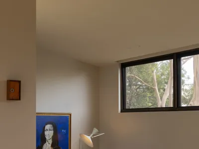 Modern living room corner with brown leather sofa, terracotta sectional, marble ledge, terrazzo coffee table, and a large framed Mona Lisa painting under warm lighting.
