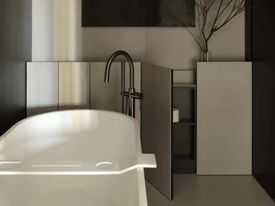 Modern minimalist bathroom featuring a white freestanding bathtub, matte concrete walls, black matte faucet, dark abstract painting, and dried branches in a glass vase.