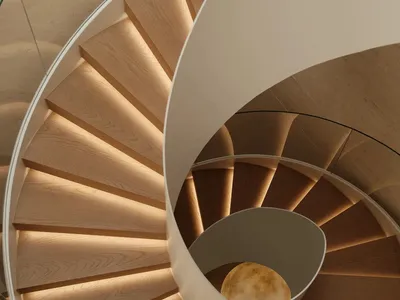 Top-down view of a modern spiral staircase made of light oak with integrated warm LED lighting under each step, featuring a white curved central structure and glass railing.