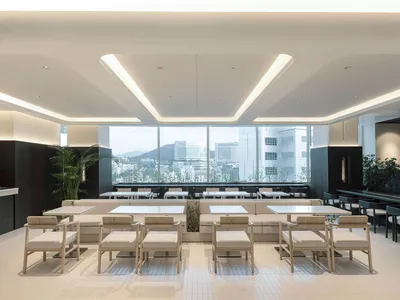 Modern minimalist restaurant interior featuring light wood chairs, white upholstered banquettes, white tables, and large panoramic windows overlooking a cityscape and mountains.