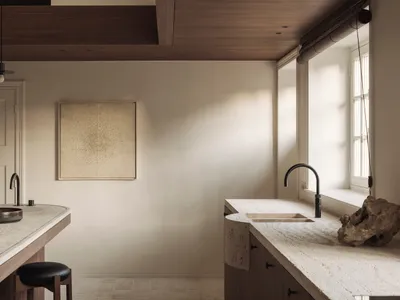 Modern minimalist kitchen featuring a curved travertine island and countertop, dark wood cabinetry, black leather stool, and large window with natural sunlight.