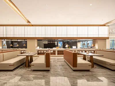 現代優雅的餐廳用餐區，設有白色與棕褐色皮革卡座、大理石餐桌，以及拋光灰色大理石地板。