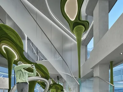 一名男子在現代零售空間內揮桿，空間內有大型有機綠色植絨雕塑、戲劇性燈光與玻璃樓梯。