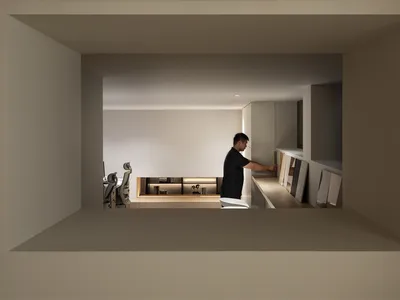 男子站在極簡浮動工作檯前，現代在家辦公室擁有溫暖氛圍照明與純白牆面。