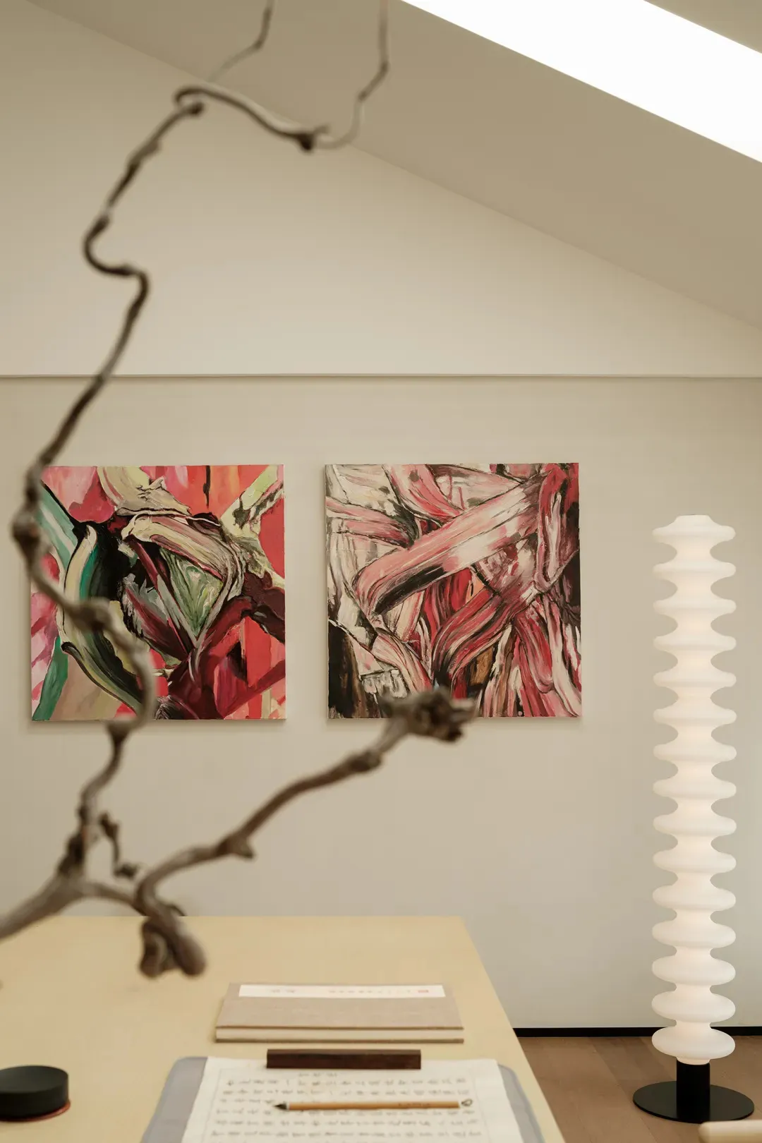 A modern interior space featuring abstract art with red, pink, and black colors.