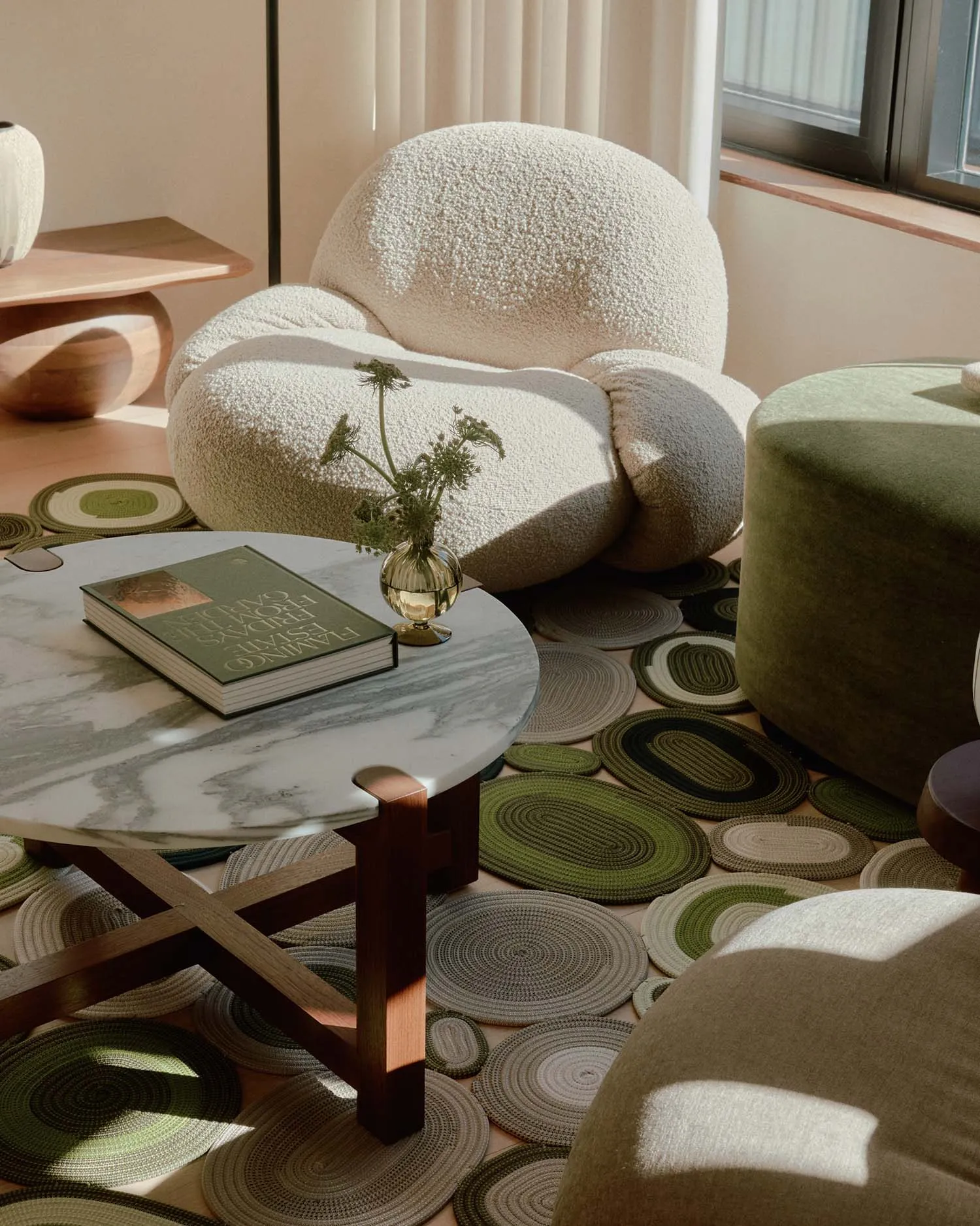 A modern living room featuring a plush, textured couch and various textured textiles on the floor.