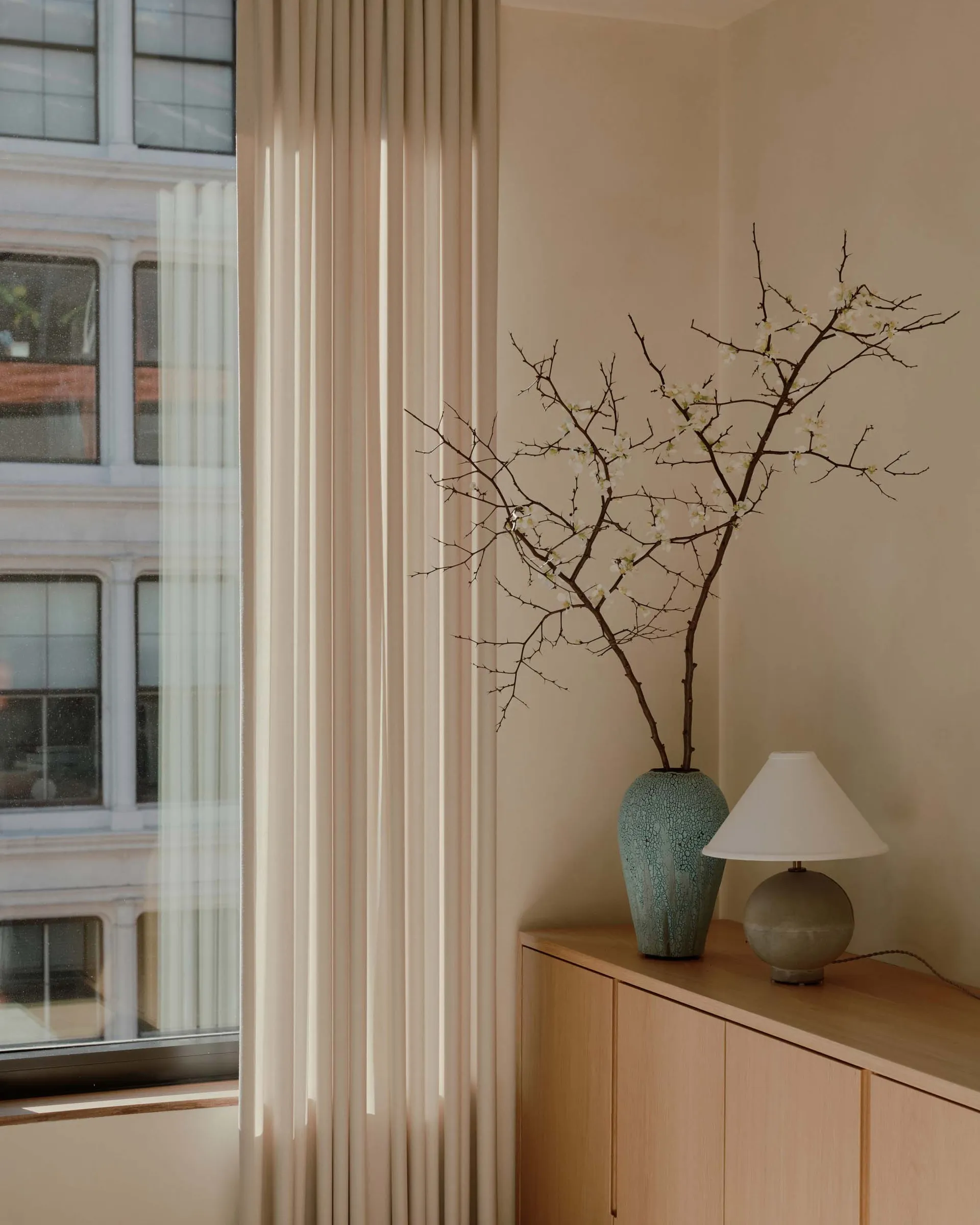 A modern, neutral-toned living room featuring minimalist decor and soft lighting.