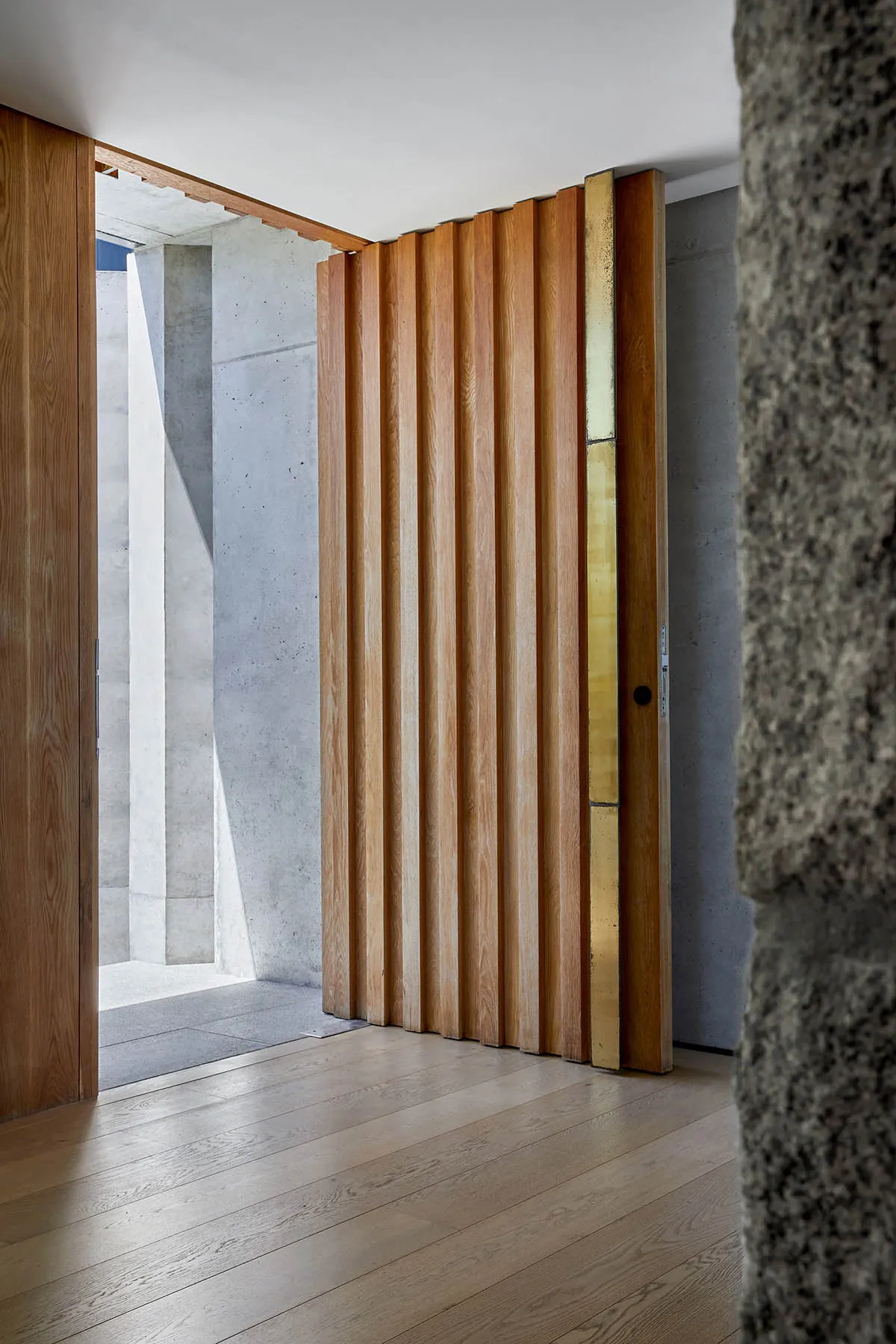 A wooden folding door with metallic accents in a modern interior setting.
