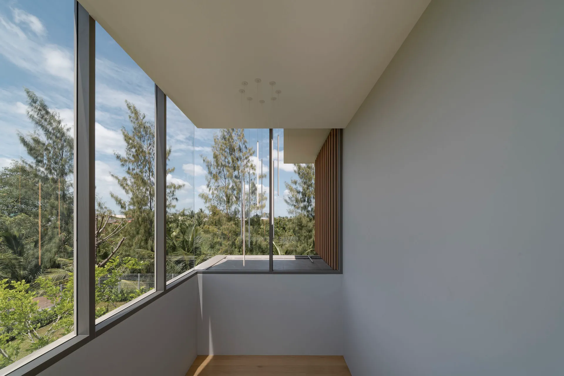 Modern minimalist interior with large glass door opening to outdoor area.