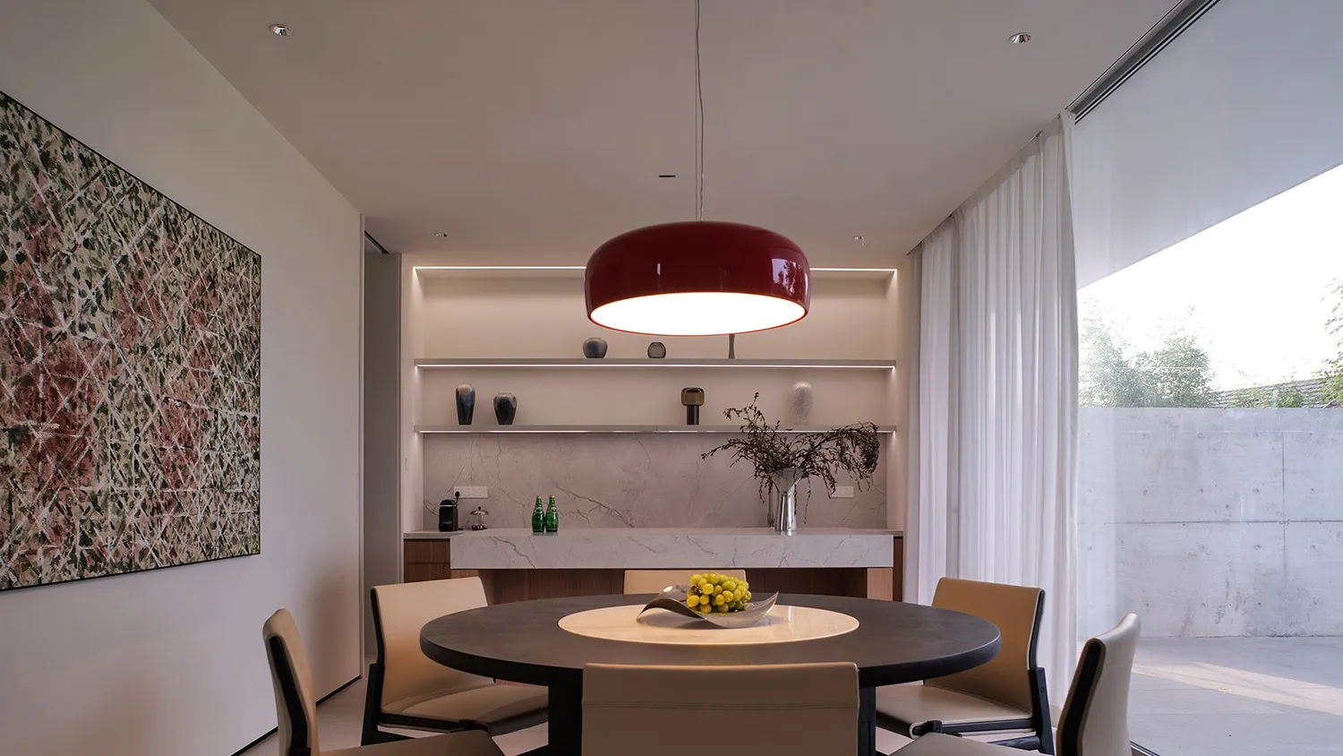 Modern dining room interior with minimalist design, featuring concrete materials and a centrally placed round table.