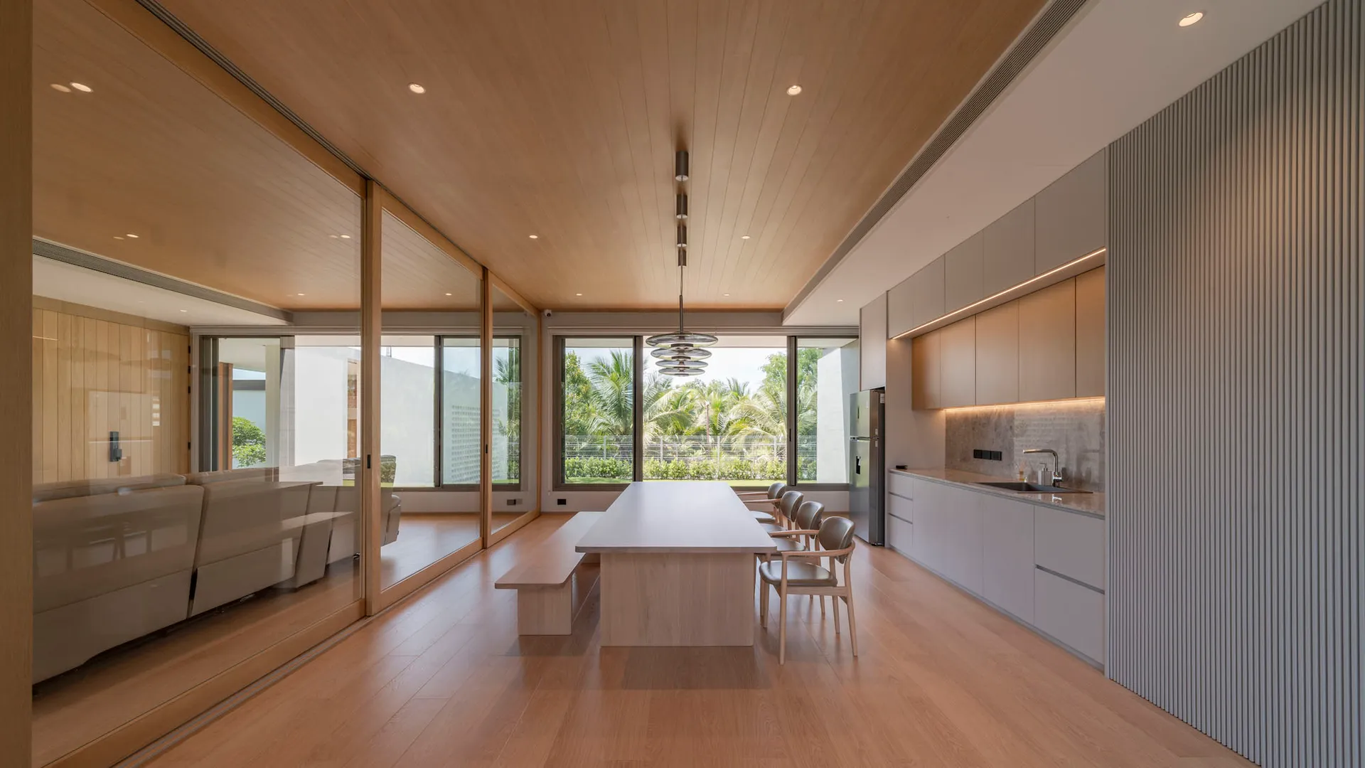 Minimalist modern kitchen dining and living room with wood and metallic accents.
