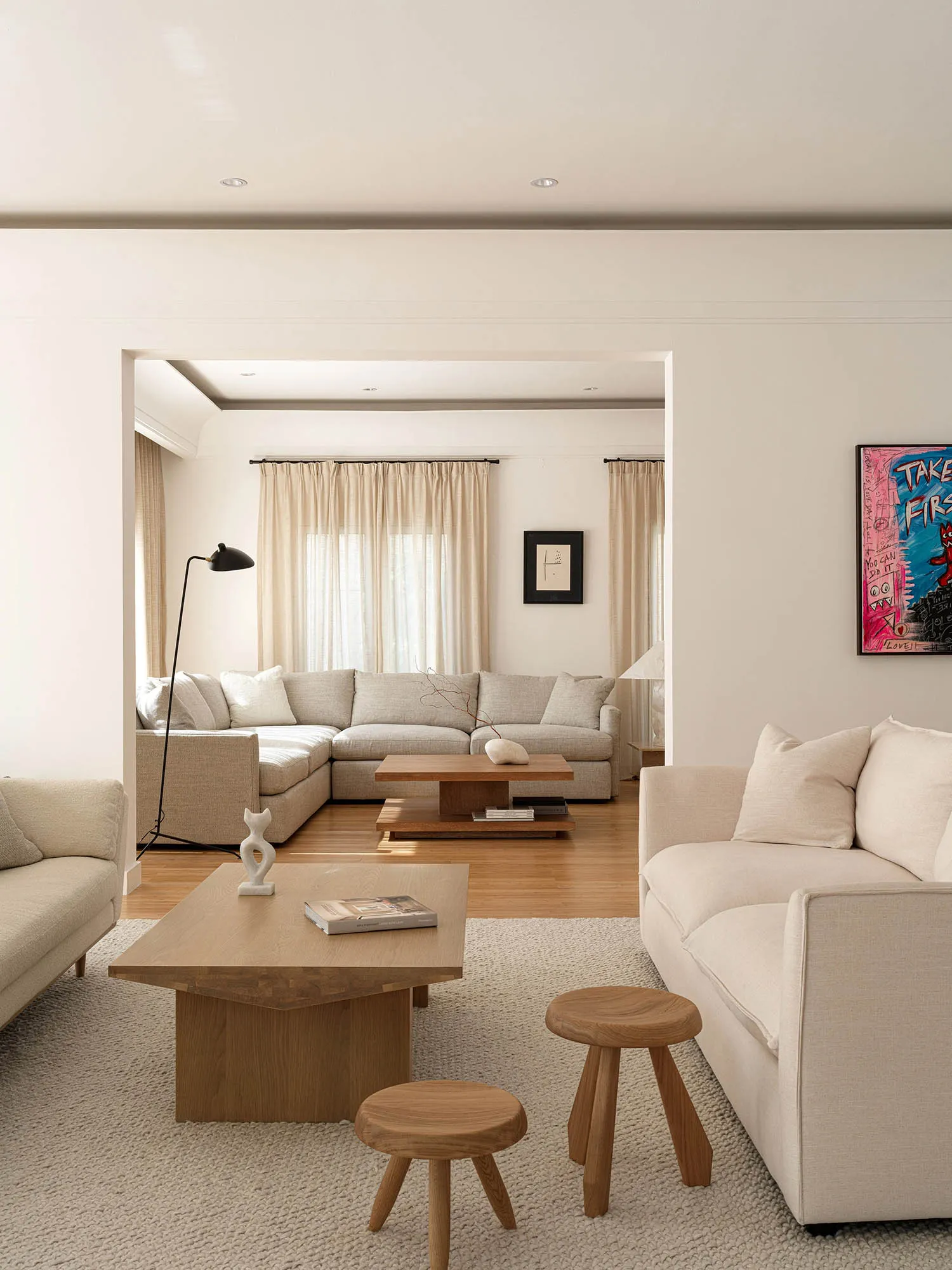 A well-designed, minimalist modern living room with neutral tones and stylish furniture.