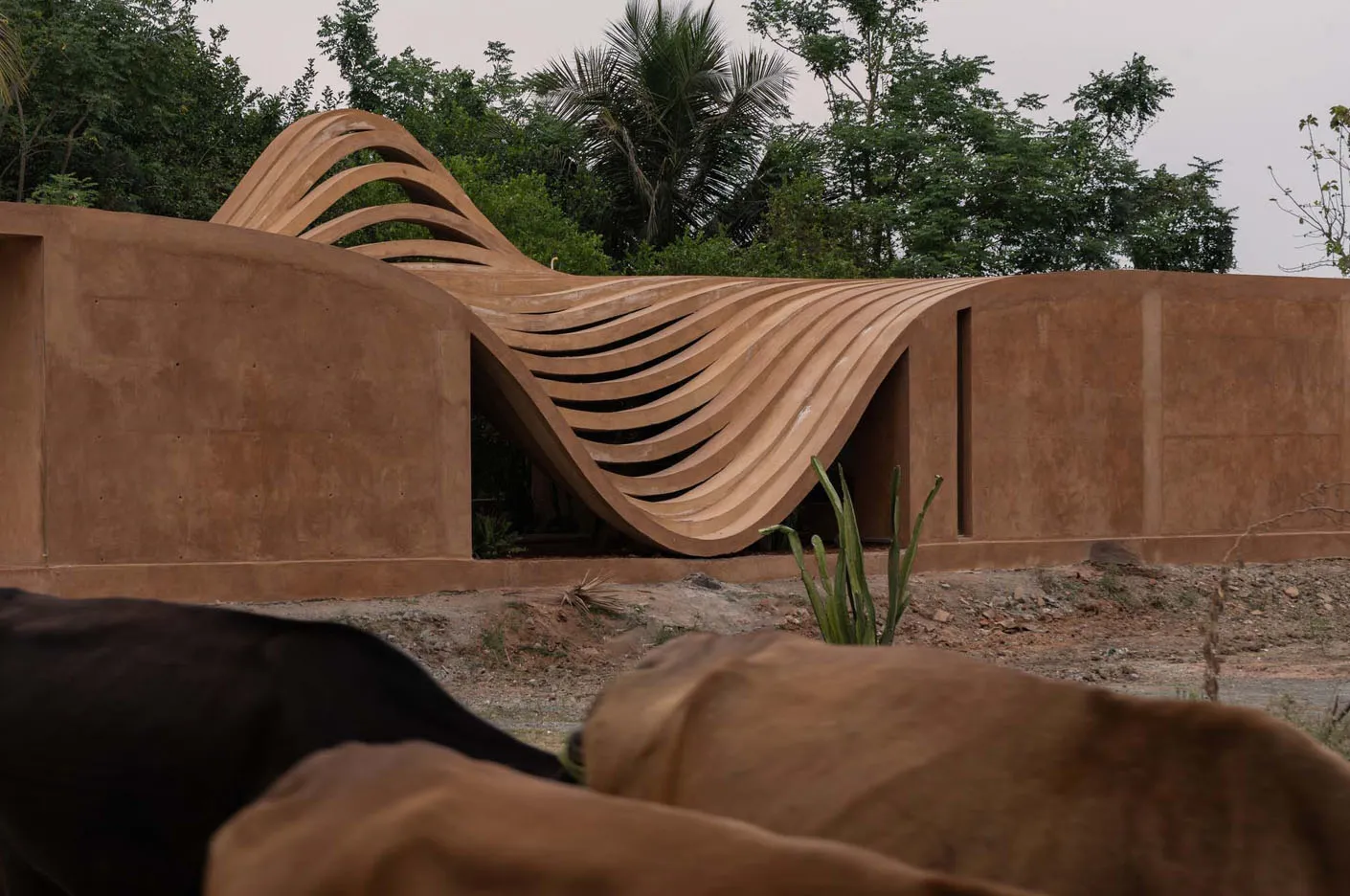 A modern architectural design featuring a wave-like structure made of concrete.