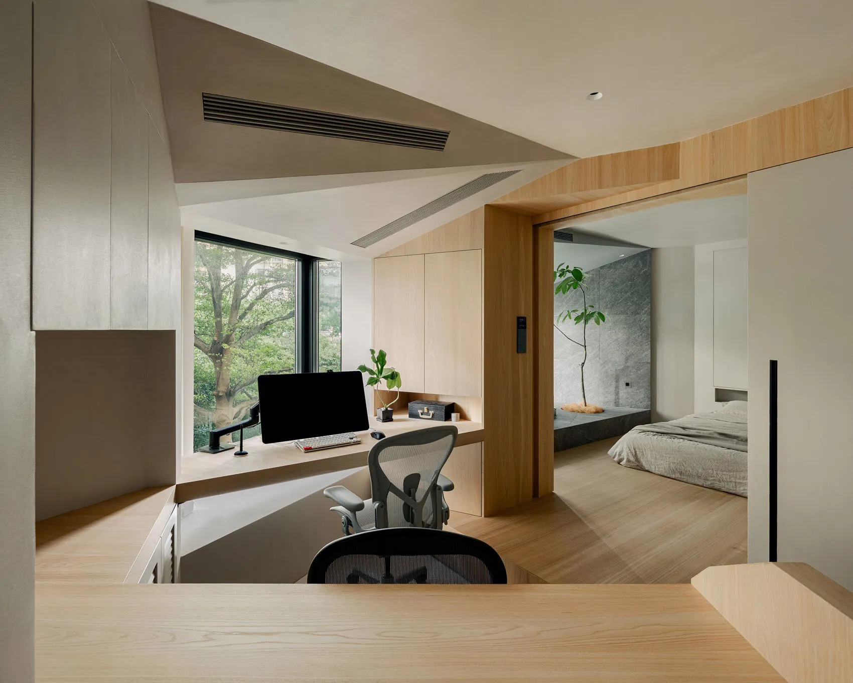 A minimalist home office with wooden walls, a sleek desk, and shelves filled with books and decor.