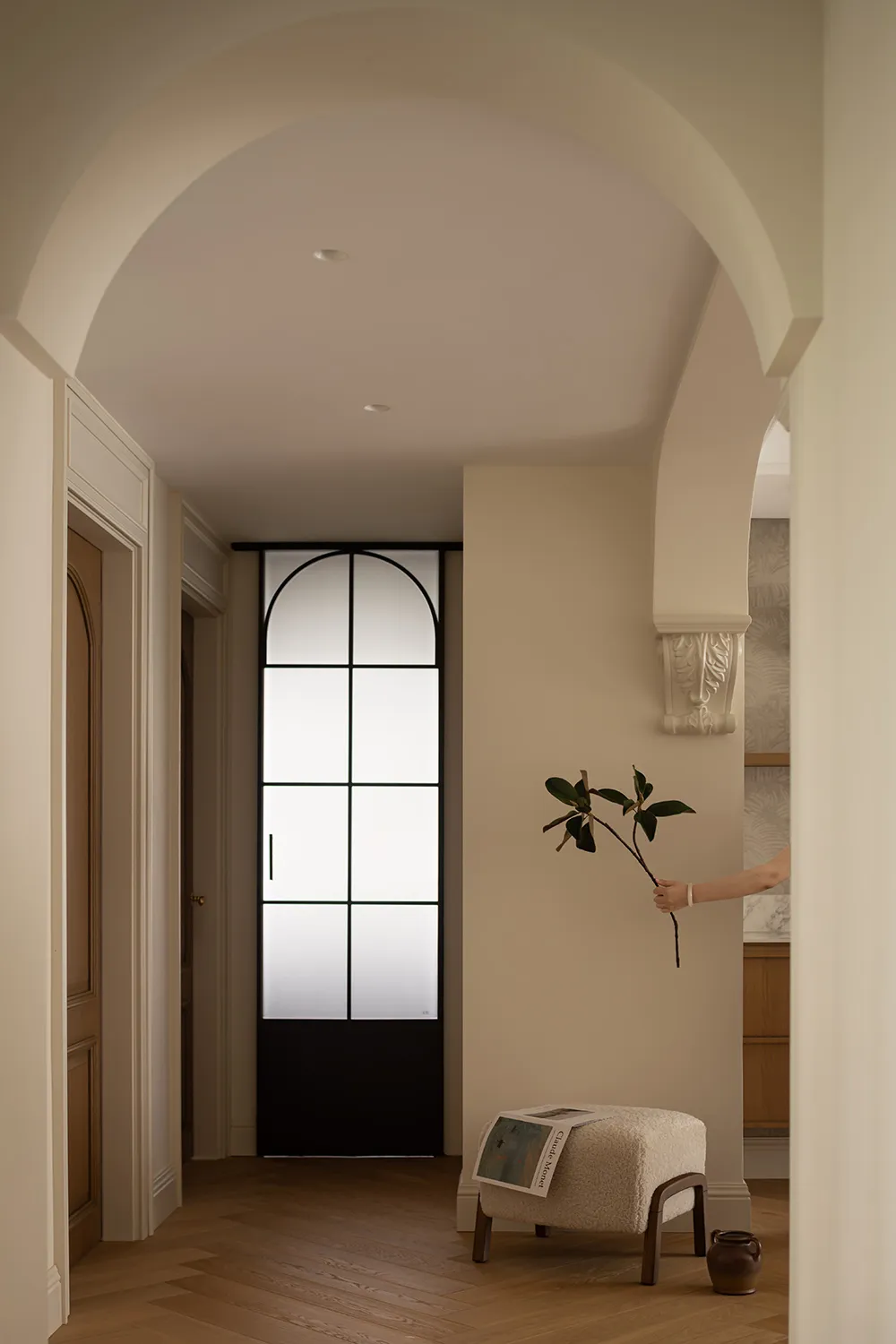 A minimalist living room featuring a wooden floor and white walls.