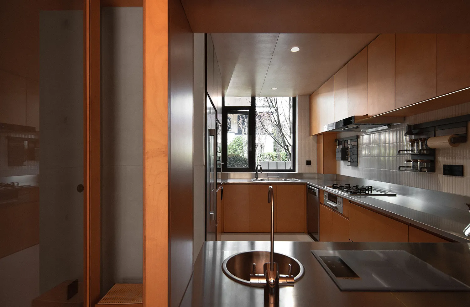 Modern kitchen with sleek countertops, stainless steel appliances, and contemporary wooden cabinetry.